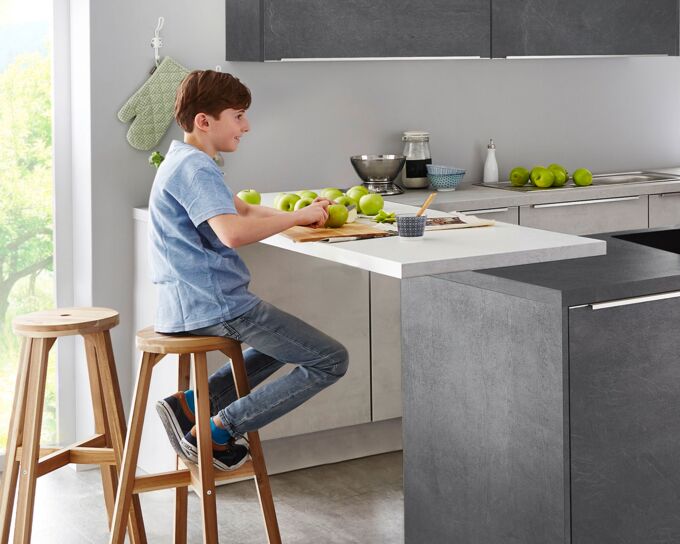 Junge schneidet Äpfel an Küchentheke