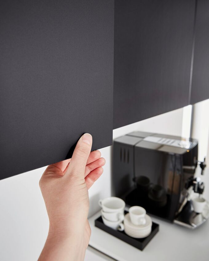 Hand berührt Küchenfront mit Anti-Fingerprint Beschichtung