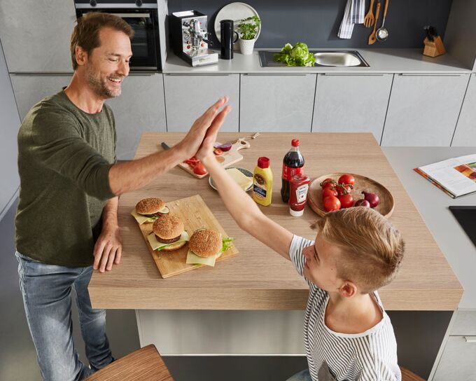 Vater und Sohn machen Burger an der Pultplatte